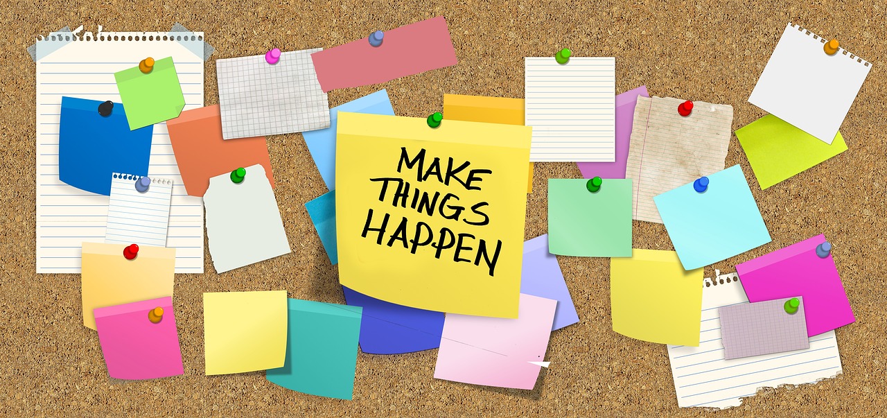 post-it notes and blank pieces of paper pinned to a notice board