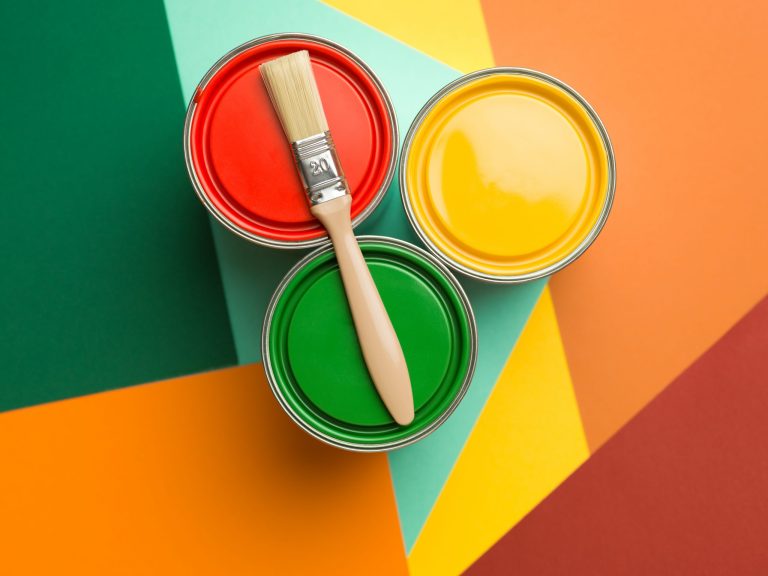 Three paint pots with a Bruch resting on top.