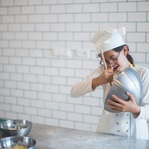 girl in chefs hat baking