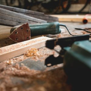 sander lying on it's side along with some wood and shavings