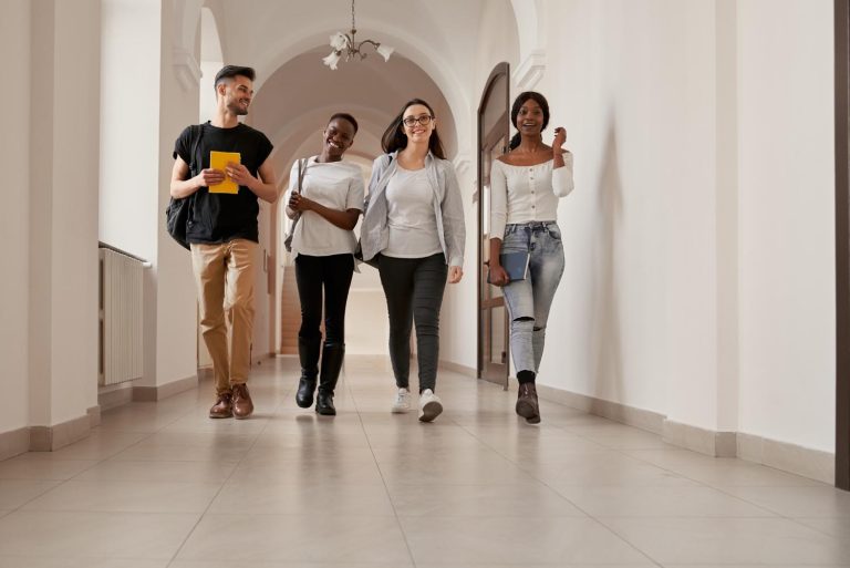 Group of young people walking through a long corridor.
