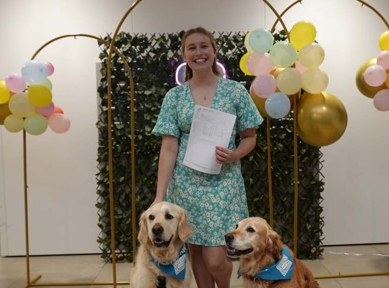 Student holding paper, with two dogs