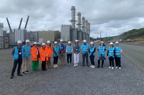 Group of staff and students in high viability jackets outside refinery