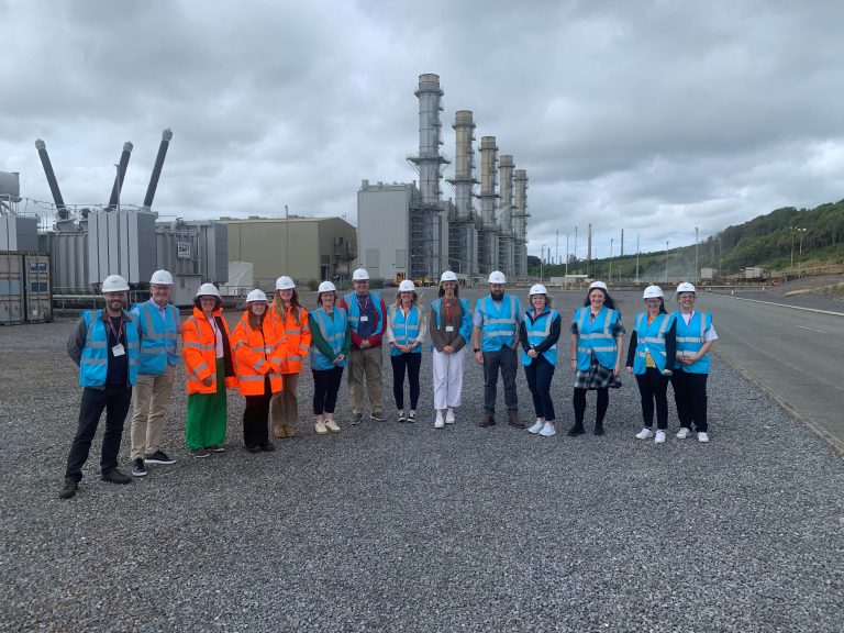 Group of staff and students in high viability jackets outside refinery