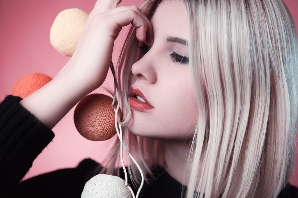 blonde female holing brown string lights