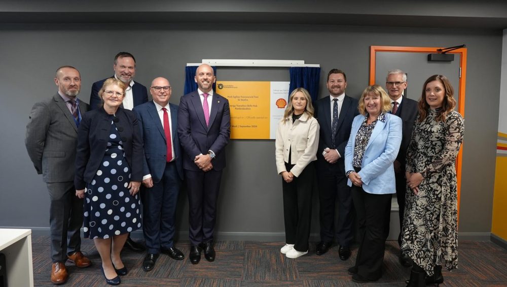 Two groups of people standing either side of plaque