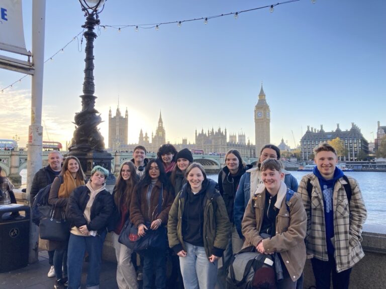 Group of students standing by the Thames with Westminster in background.