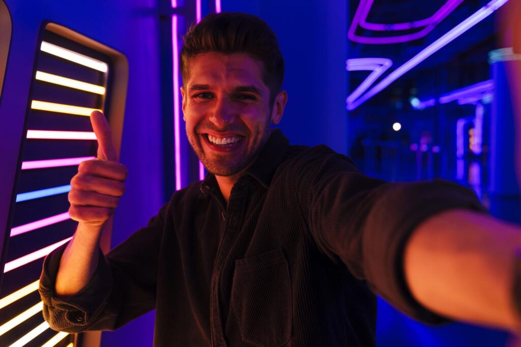 Young man showing thumb up while taking selfie photo
