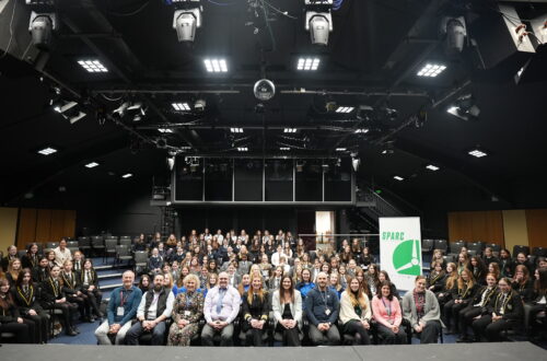 SPARC Alliance including young females and teachers sat in the Merlin Theatre facing the stage