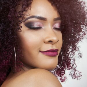 Lady with curly hair, eyes closed with makeup