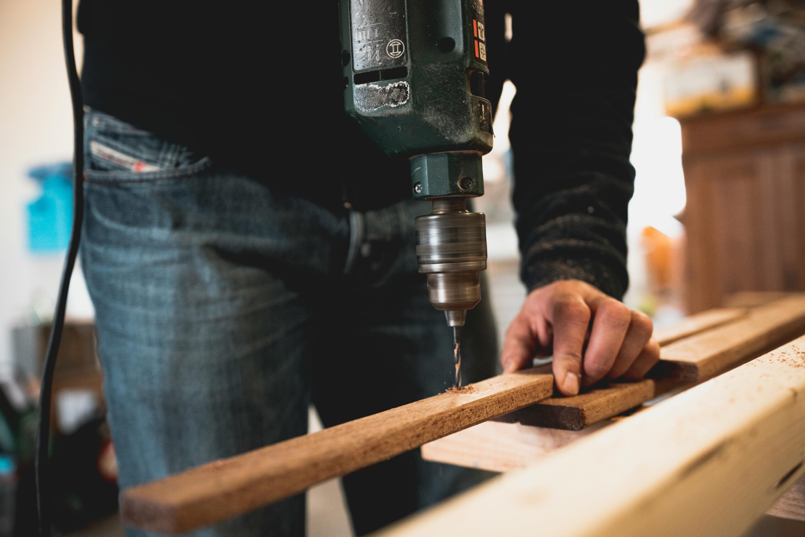 man drilling a piece of wood