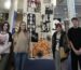 Four Art learners stood in front of large banner