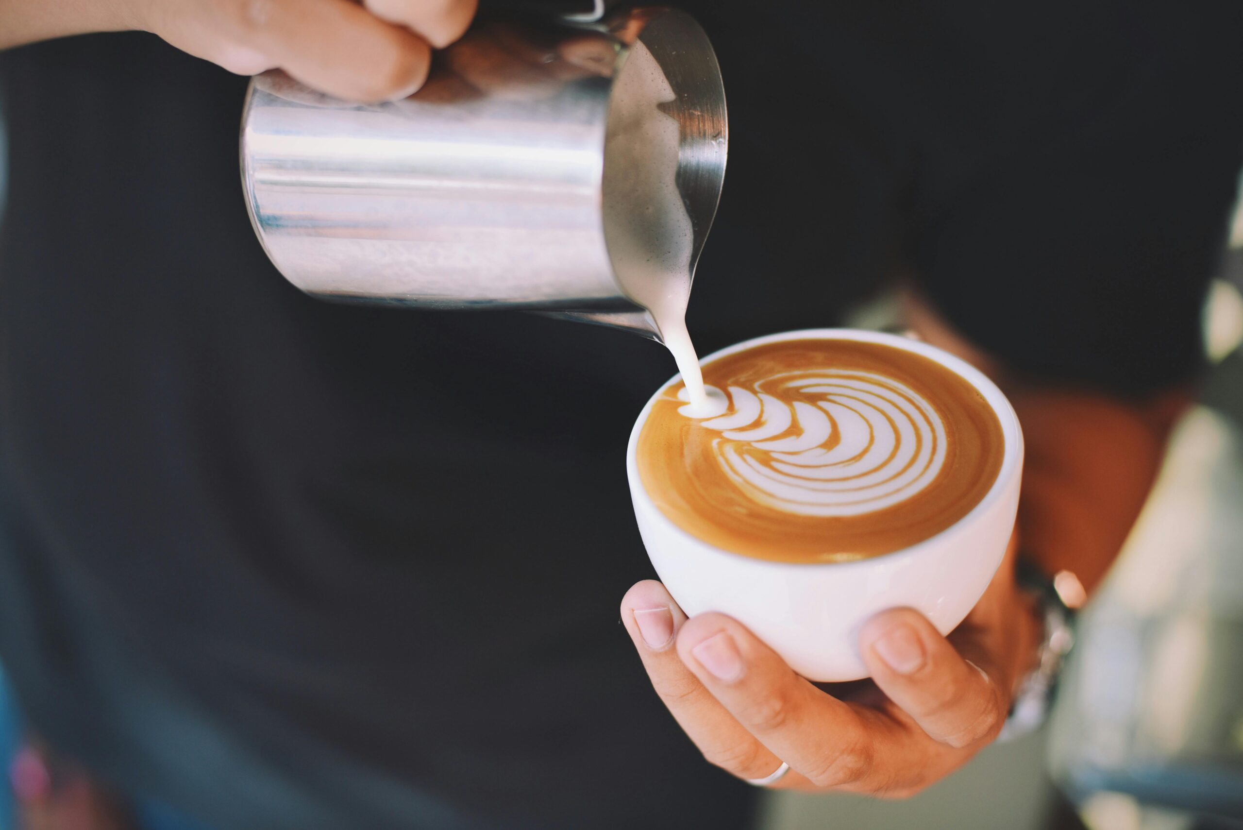 POURING MILK INTO A COFFEE