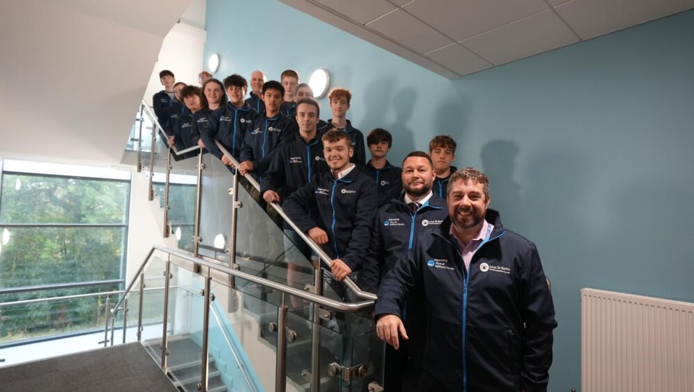 Group of staff and students on the stairs.