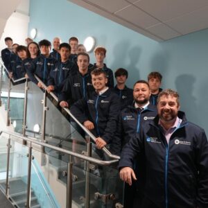 Group of staff and students on the stairs.