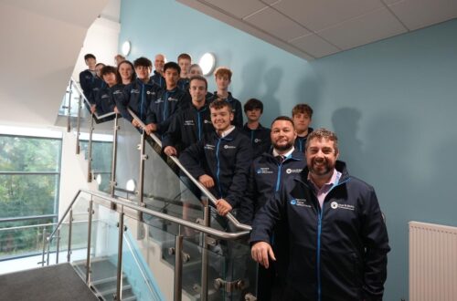 Group of staff and students on the stairs.