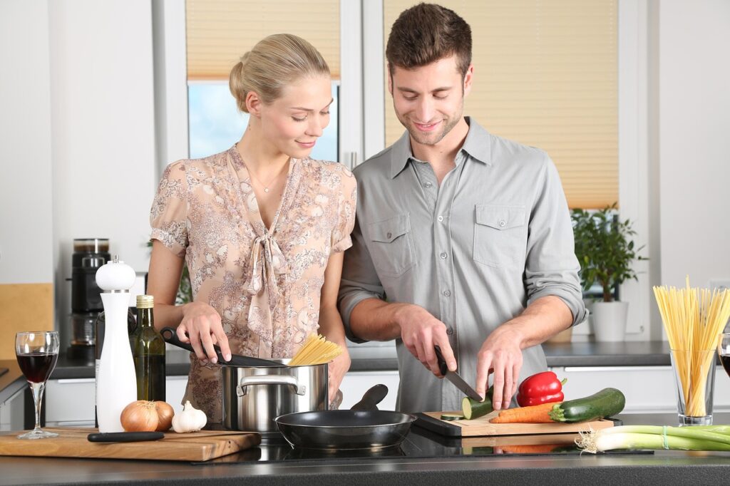 Two people preparing vegetables together ready to cook with.