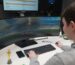 Back of student sitting at wide screen playing Esport game.