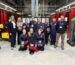 Group photo students and staff in welding workshop.