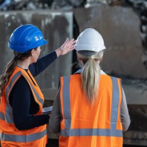 Two female construction workers in hi-vis vests and hard hats