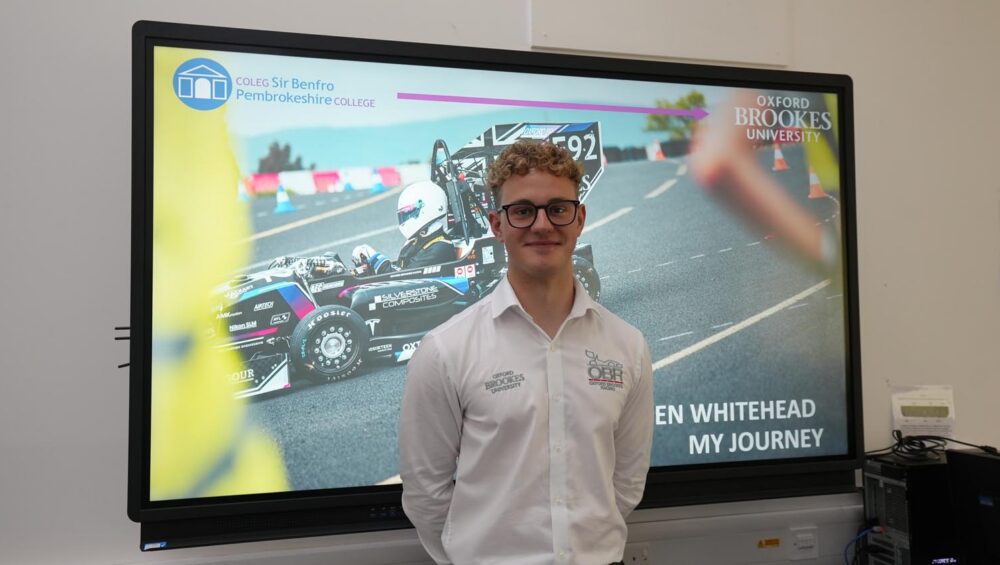 Engineering student standing in front of screen.