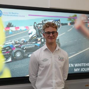 Engineering student standing in front of screen.