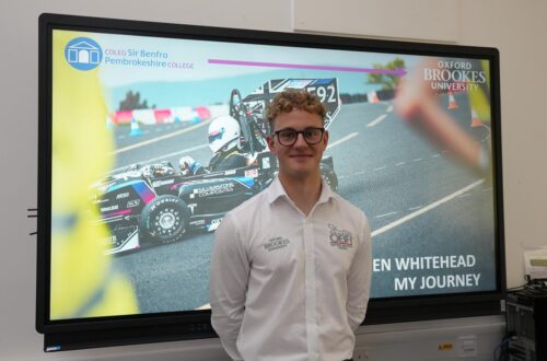 Engineering student standing in front of screen.
