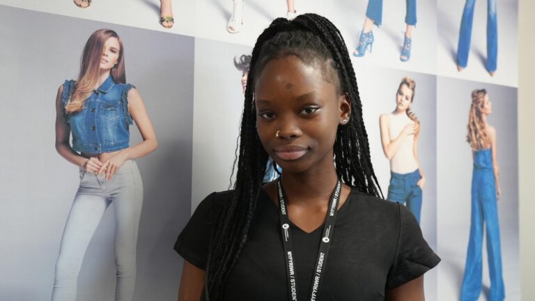 Portrait of student with posters behind.