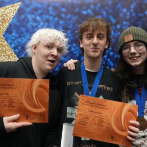 Tri pherson yn dal tystysgrifau ac yn gwenu.