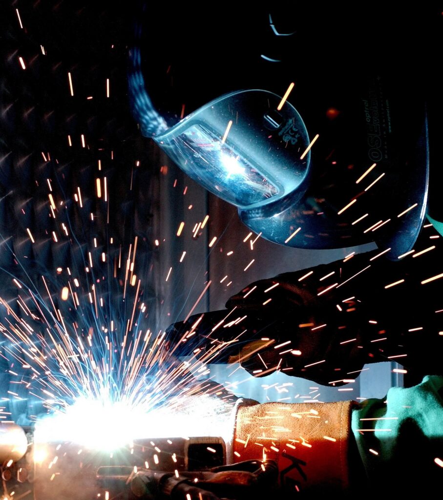 Welder at work with tools and mask.