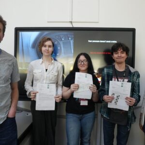 Creative Media lecturer and learners in classroom holding certificates.