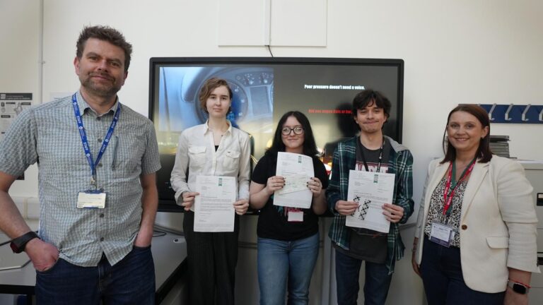 Creative Media lecturer and learners in classroom holding certificates.