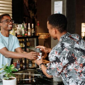 Barista joyfully serving a customer a coffee