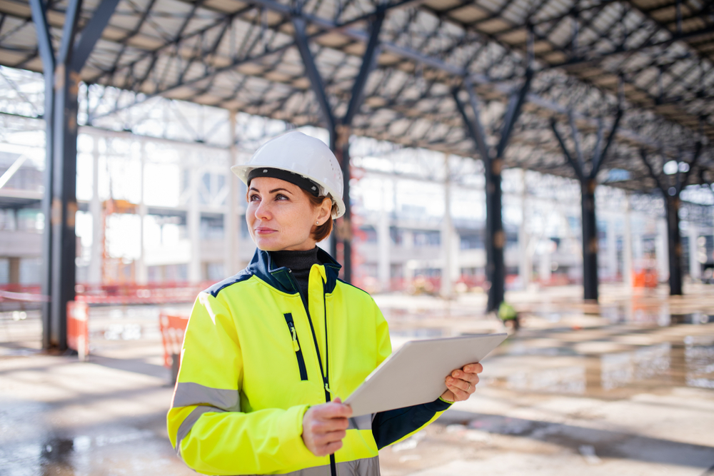 A female in a high vis vest holding a piece of paper