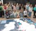 Group of students and staff standing behind a map of the UK on the floor.
