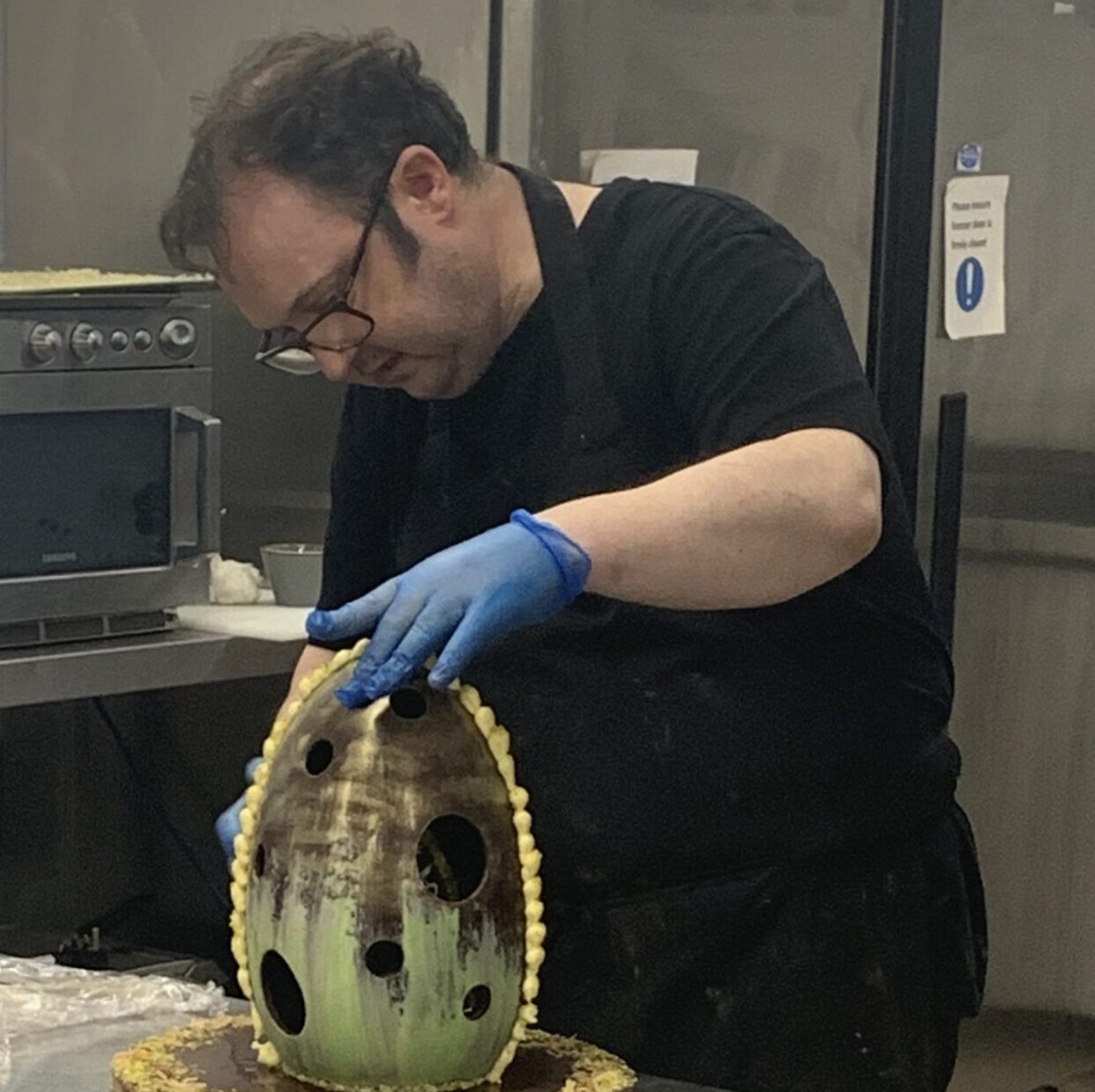 Student working on a large chocolate egg.