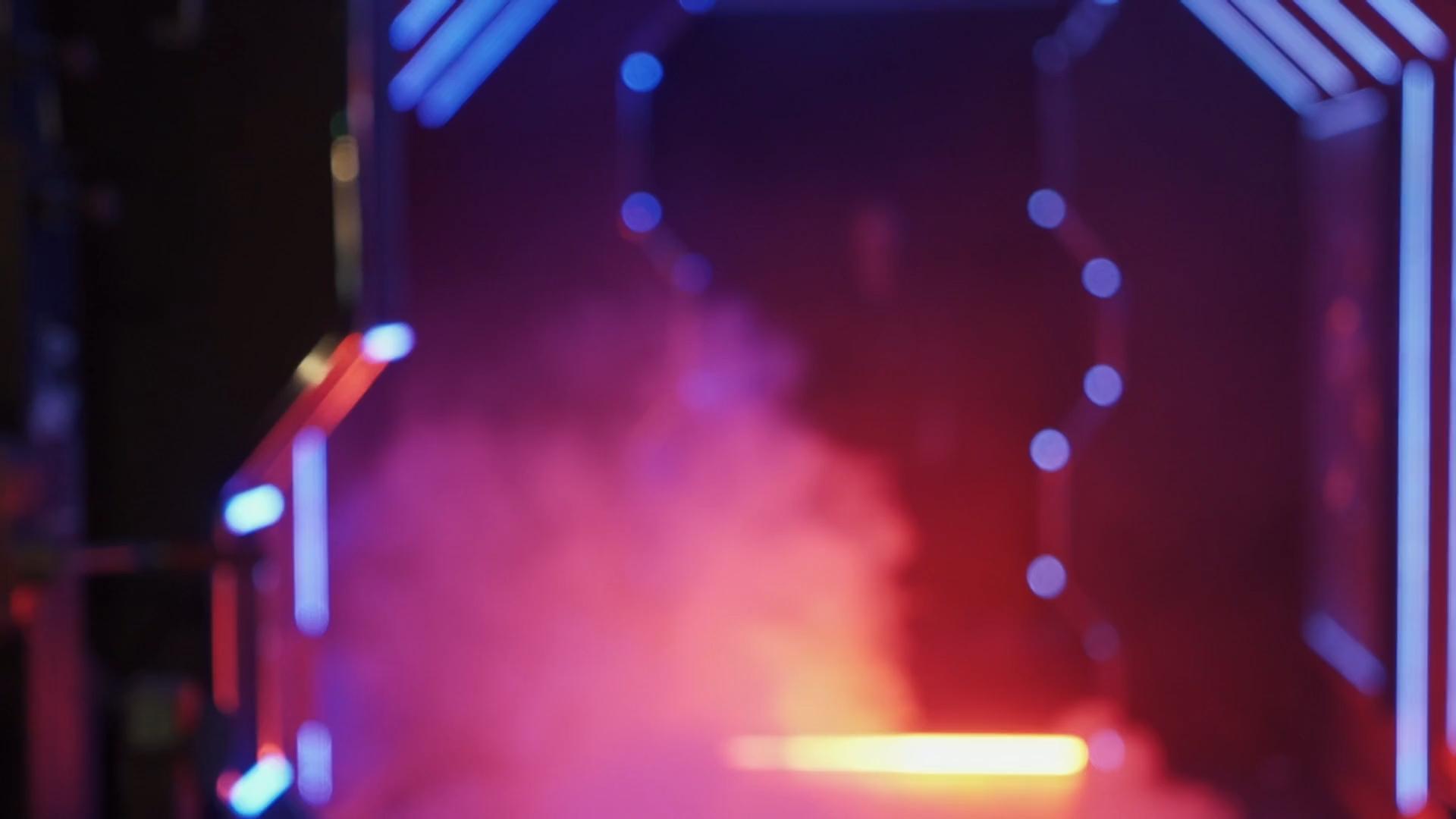 Person, with face paint, standing in futuristic area lit by neon lights